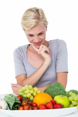 Happy blonde woman sitting above healthy food