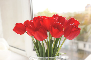 Bouquet of fresh tulips on windowsill background