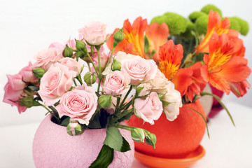 Beautiful flowers in pots on light background