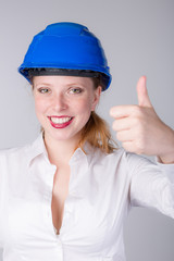 Junge Ingeneurin mit Schutzhelm lacht