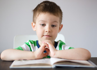Little boy is reading a book