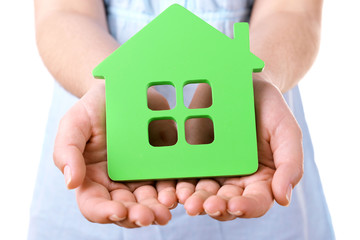 Female hands with small model of house, closeup