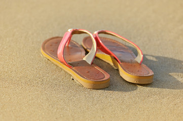Fototapeta na wymiar Summer vacation concept. Sandals on a sandy ocean beach