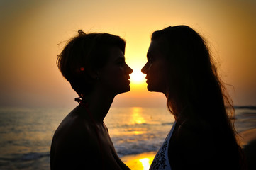 Silhouette couple over sunset background