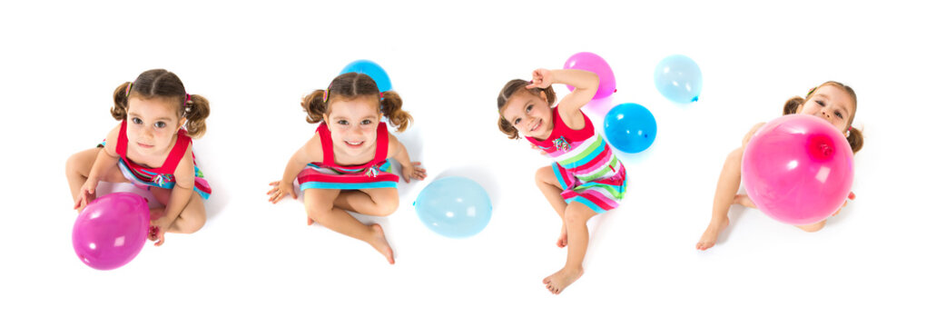 Kid playing with balloons over white background