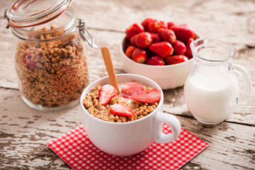 Healthy breakfast. Bowl of milk with granola and strawberries.