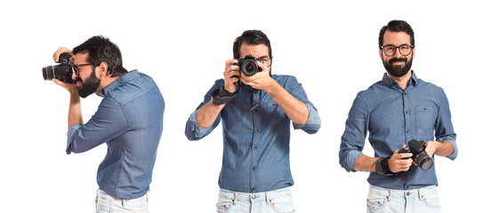 Young hipster man photographing over white background