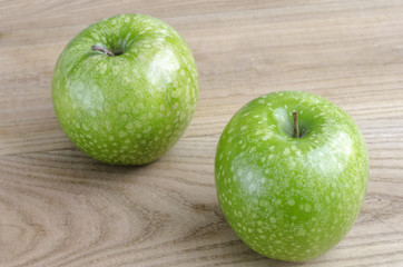 Two green apple over wood.