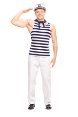 Fototapeta premium Young male sailor standing straight and saluting