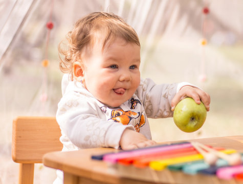 little girl eating an apple, nature, musical toys