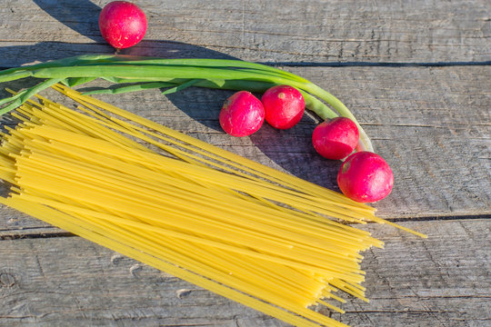 Pasta  and redis on a wooden board rough.