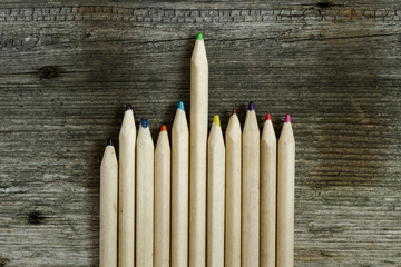 multicolored pencils on wooden table background