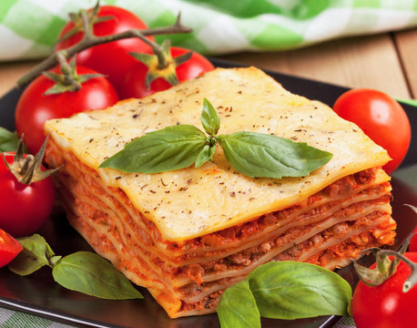 Tasty flavorful lasagna on a plate and ingredients