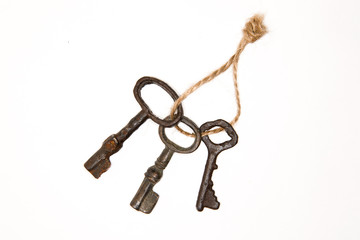 A lot vintage keys on a rope on a white background