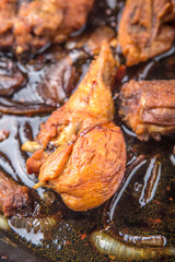 Deep fried chicken in with black soy gravy in a saute pan