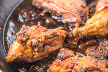 Deep fried chicken in with black soy gravy in a saute pan