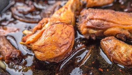 Deep fried chicken in with black soy gravy in a saute pan