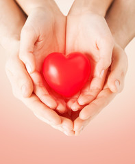 close up of couple hands holding red heart
