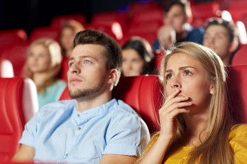 happy friends watching horror movie in theater