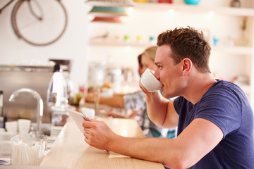 Young man using tablet computer in a cafe