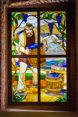 Stained glass old window with the image of a winemaker with a