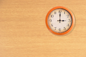 Clock showing 3 o'clock on a wooden wall
