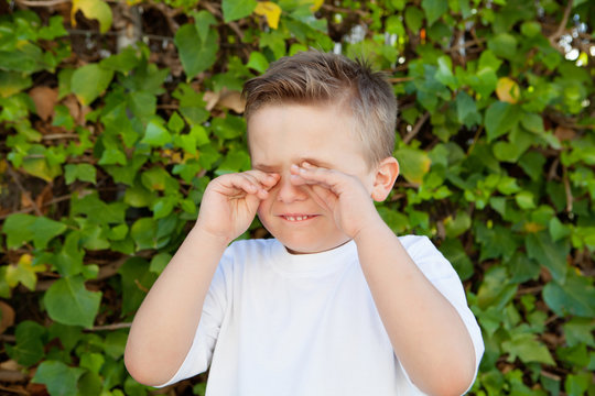 Little boy rubbing eyes for allergy