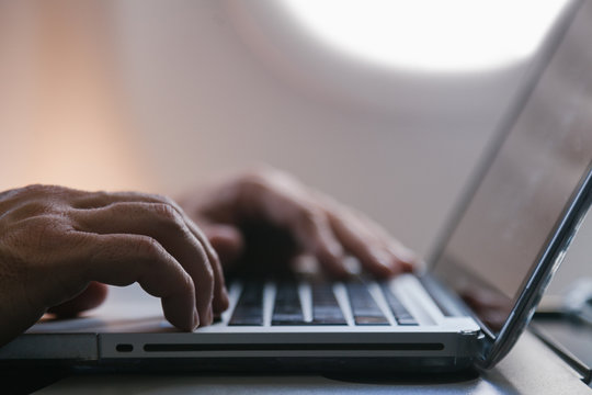 Young Man Using a Laptop during a Flight