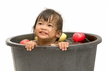 little girl playing with water in little plastic bath tab