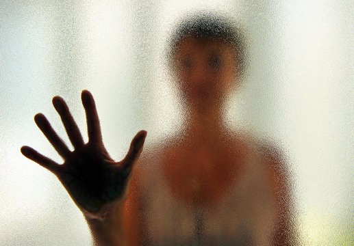 Woman behind the glass. Woman in quarantine isolation