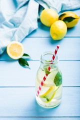 Lemon water in glass on blue wooden table
