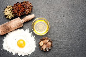 baking background with raw egg, flour, rolling pin, spicy