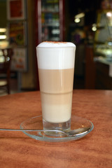 Latte Macchiato In Glass Cup On The Wooden Table    