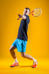 Tennis player on yellow background. Studio shot