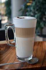 Latte Macchiato In Glass Cup On The Wooden Table    