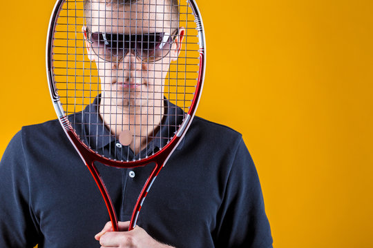 Tennis player on yellow background. Studio shot