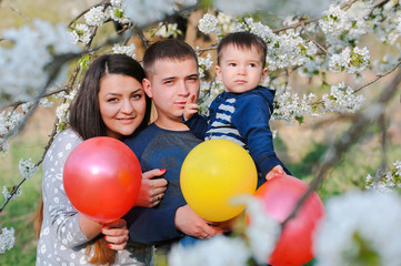 Fototapeta na wymiar Portrait of family outdoors in blooming spring garden with color