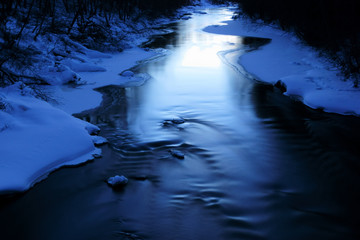 Icy blue river on cold winter evening