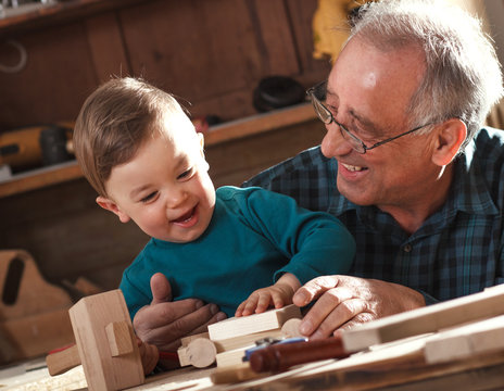 Senior carpenter and his grandson working in the workshop