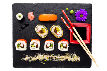 Sushi on black stone plate isolated top view
