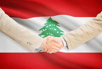 Businessmen handshake with flag on background - Lebanon