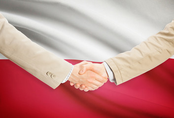 Businessmen handshake with flag on background - Poland