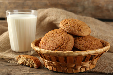 Tasty cookies and glass of milk on rustic wooden background