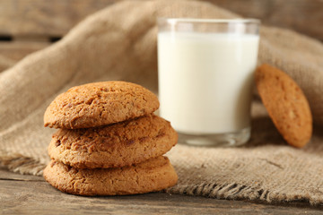 Tasty cookies and glass of milk on rustic wooden background