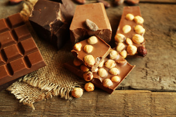 Still life with set of chocolate with nuts on wooden table, closeup