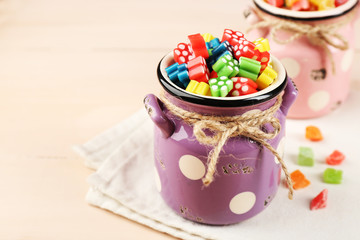 Sweet candies on color wooden table, closeup