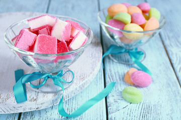 Sweet candies on color wooden table, closeup