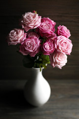Bouquet of beautiful fresh roses on wooden background