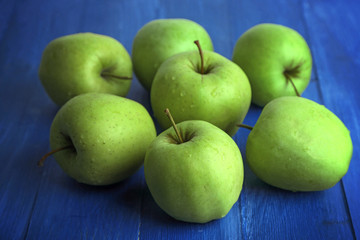 Green apples on color wooden background