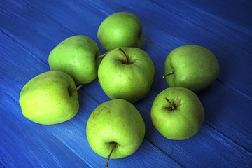 Green apples on color wooden background
